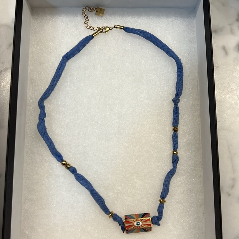 Woman blue cloth necklace with gold beads and evil eye sigh by designer